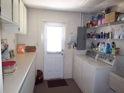 An inside laundry room has lots of counters & cabinets